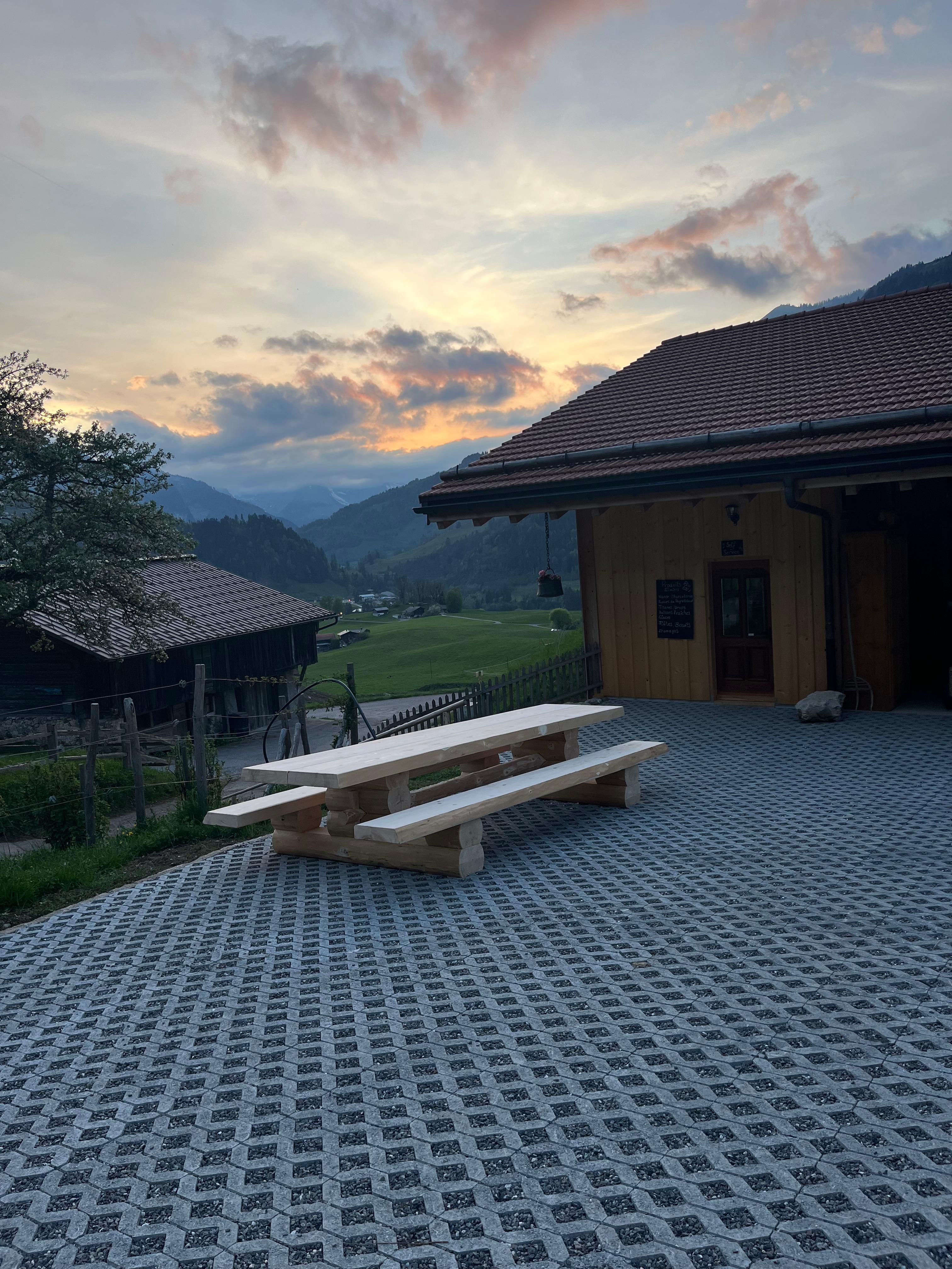 Table de pique-nique en bois devant la ferme avec vue sur les montagnes du Pays-d'Enhaut